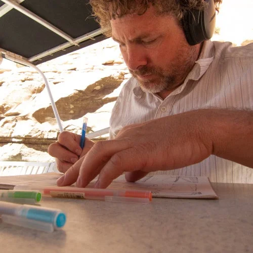 ヘッドホンを装着しスケッチをする男性