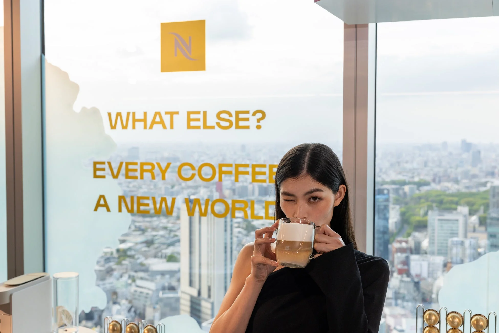 コーヒーを片手に都市の景色を眺める女性