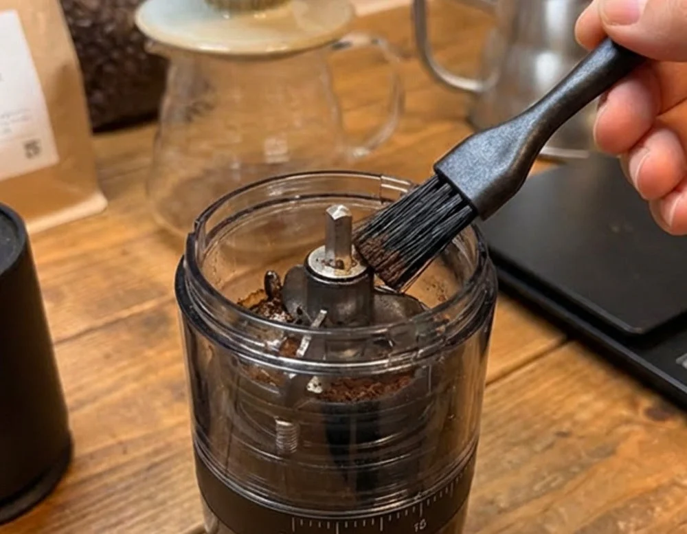 ブラシでコーヒーミルを掃除する様子