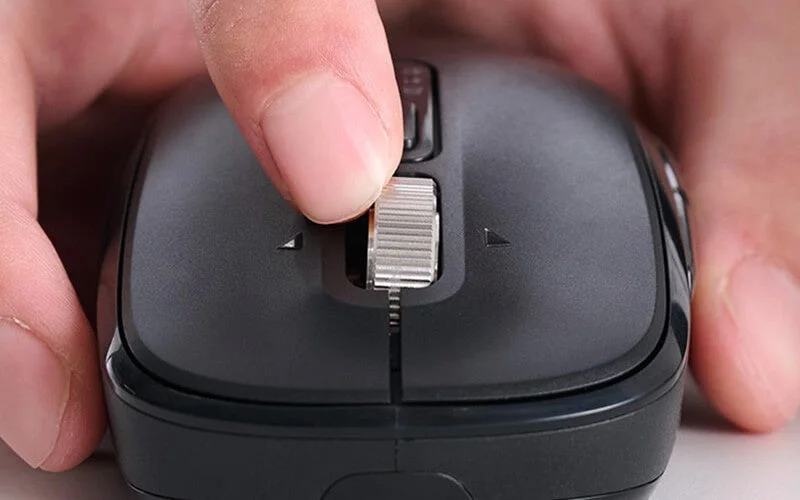 黒いマウスのホイールを操作する手