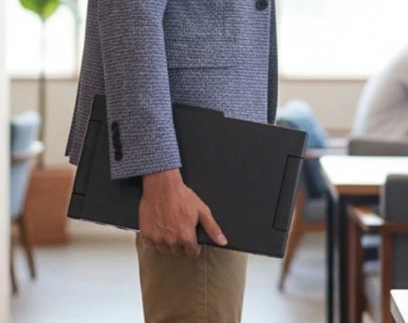 ノートパソコンを持って歩くビジネスパーソン