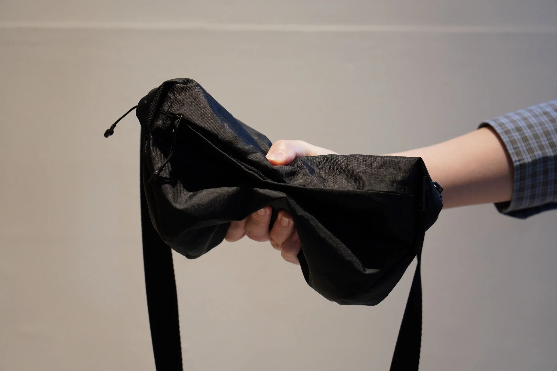 黒い布製のバッグを手で持っている様子