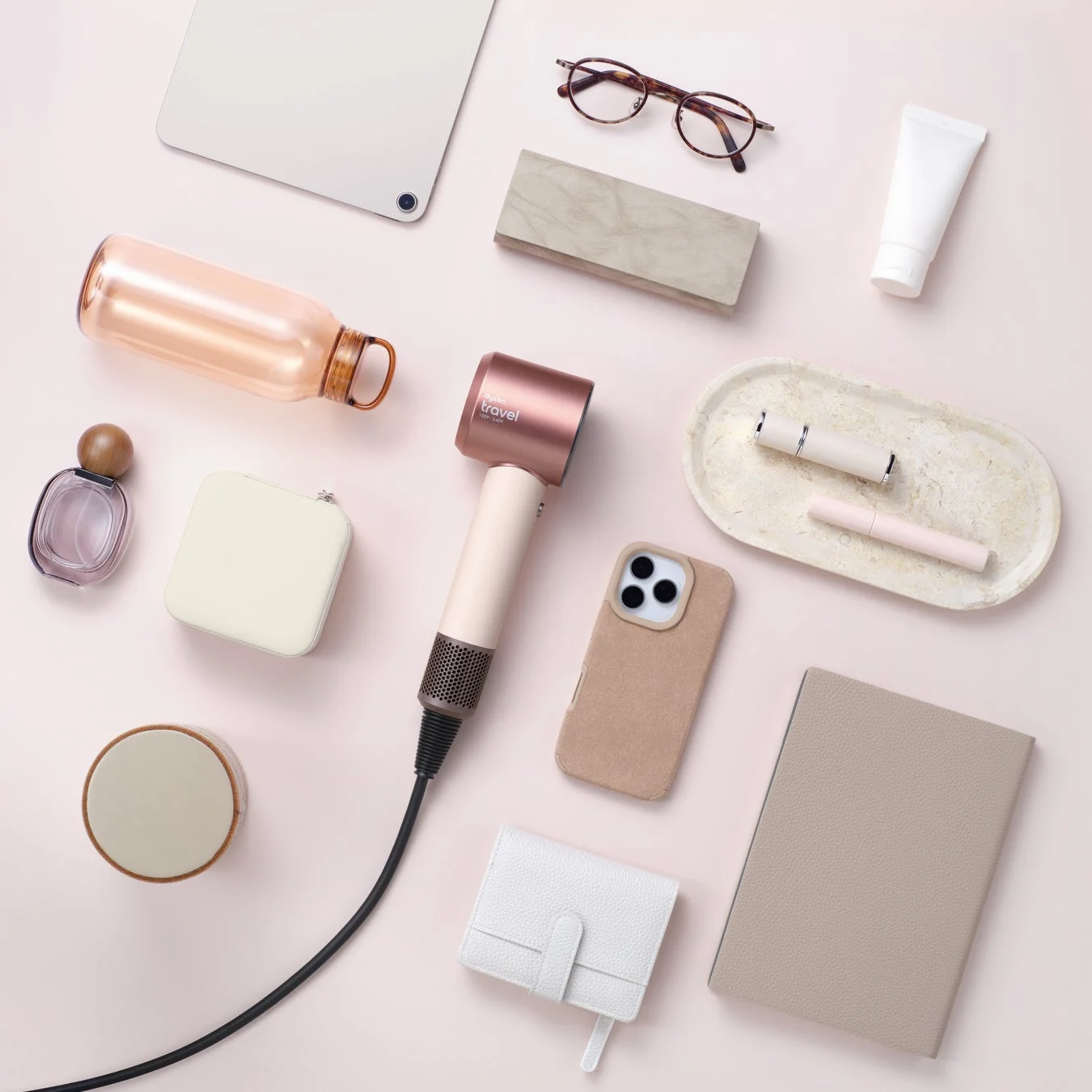 旅行アイテムと共に配置されたDyson Supersonic Travelヘアドライヤー