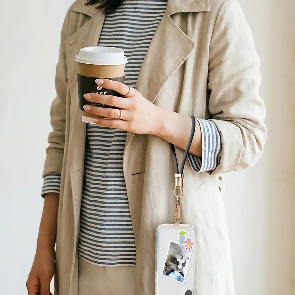 カフェでコーヒーを持ちながらスマホを腕にぶら下げている女性