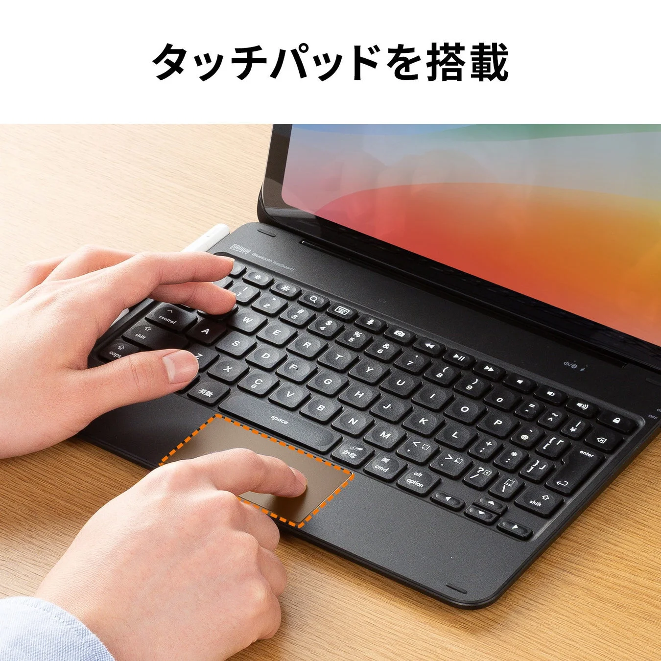 タブレットに接続されたBluetoothキーボードで作業している様子。キーボードにはタッチパッドが搭載されています。