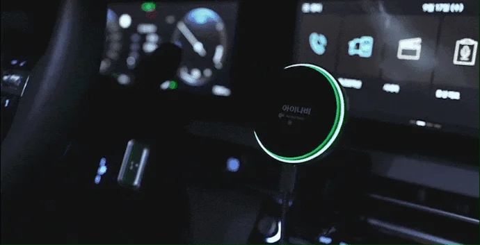 夜間の自動車内で、緑色に光る円形のデバイスが特徴的な画像。現代的な車内空間のテクノロジーを表現している。