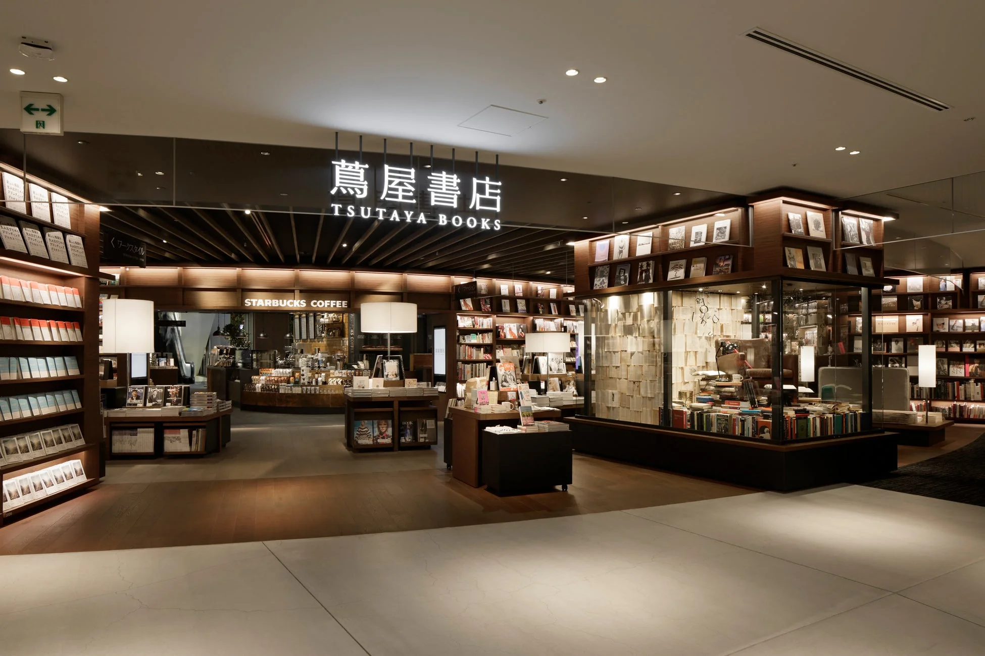 蔦屋書店とスターバックスコーヒーが併設された広々とした書店の店内風景です。木目調のモダンなインテリアで統一され、多くの書籍が並び、落ち着いた雰囲気で読書やカフェを楽しめる空間が広がっています。