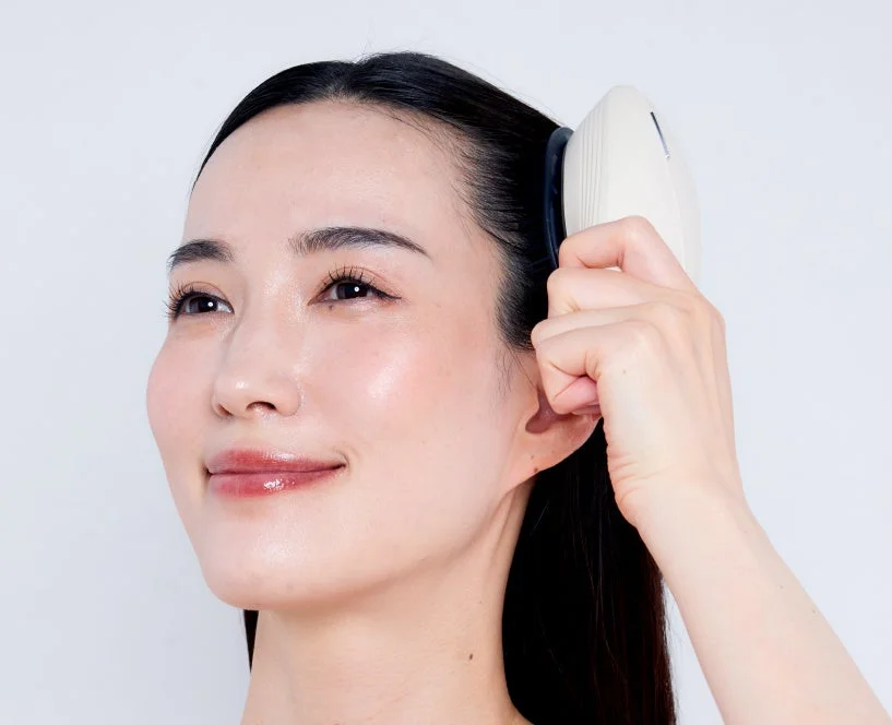 頭皮マッサージ器を使用する女性