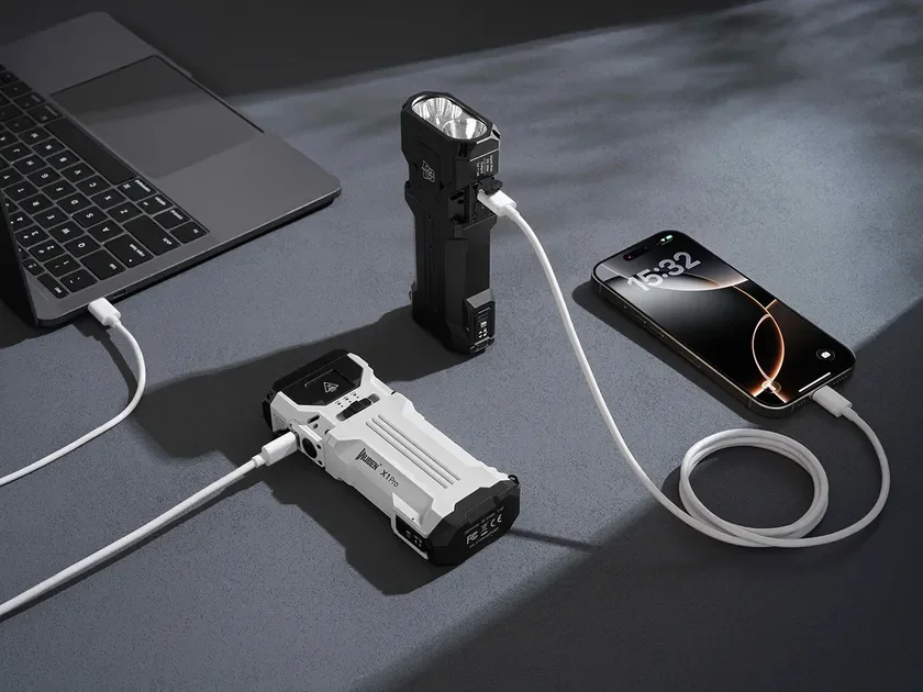 ラップトップ、スマートフォン、そして2つの多機能ポータブルデバイスが置かれ、白いケーブルで互いに接続され充電されている