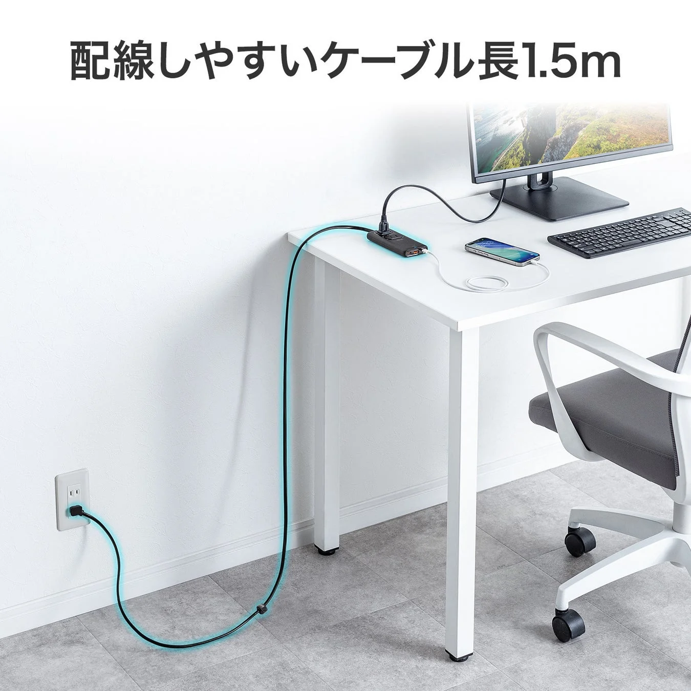 デスク周りの電源タップと、コンセントからデスクまで届く1.5mの長いケーブルが配線しやすい様子を示した画像です。モニター、キーボード、スマートフォンが配置された清潔なワークスペースが描かれています。
