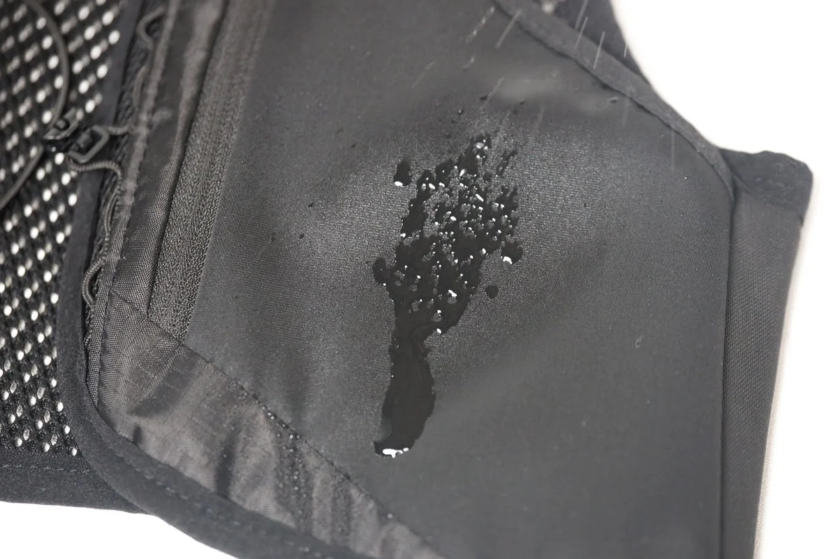 黒い生地の表面に水滴がついており、水が弾かれている様子