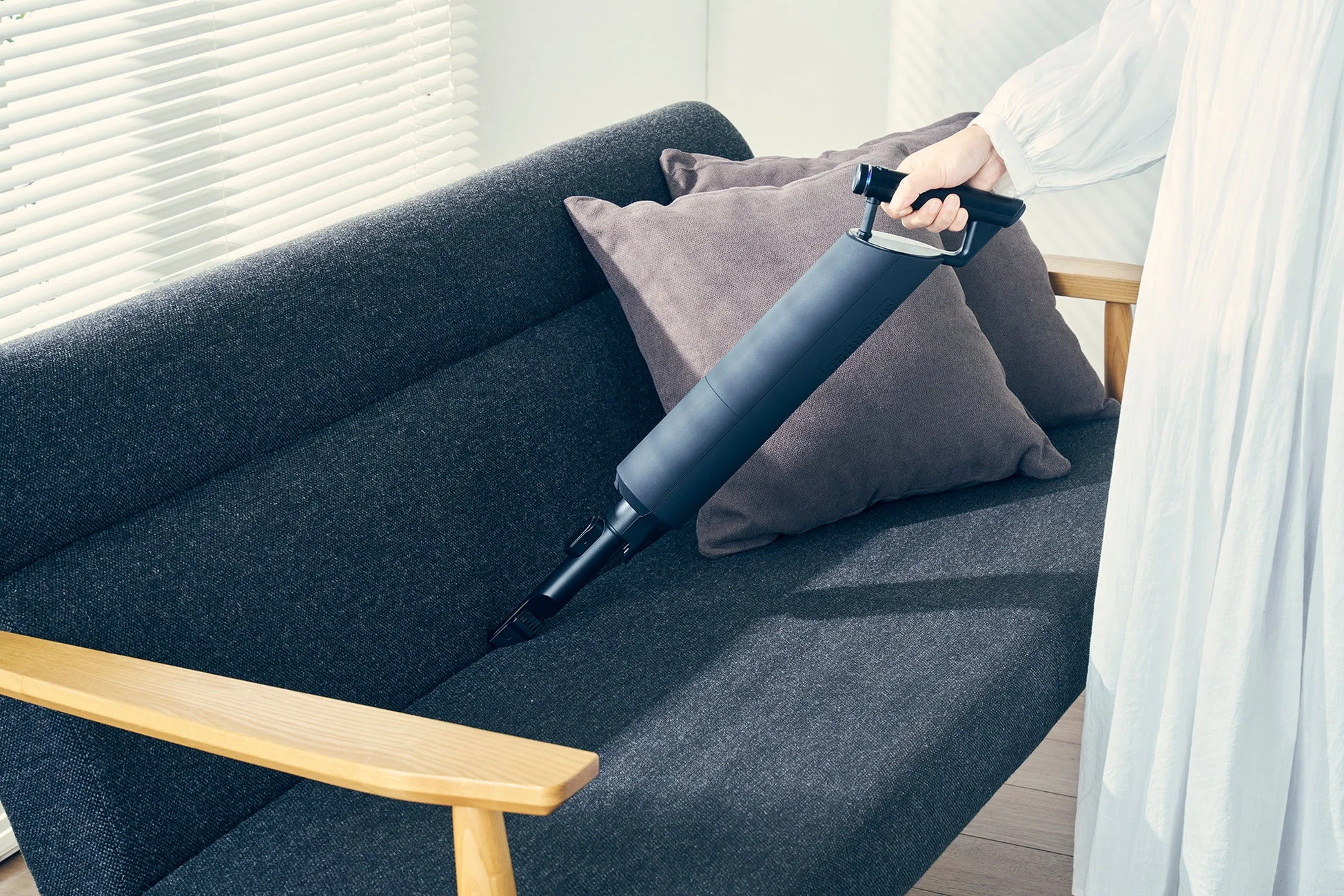 ハンディクリーナーでソファを掃除する様子
