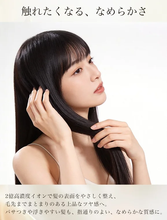 触れたくなるようななめらかな黒髪を持つ女性が、髪に触れる仕草をしている画像です