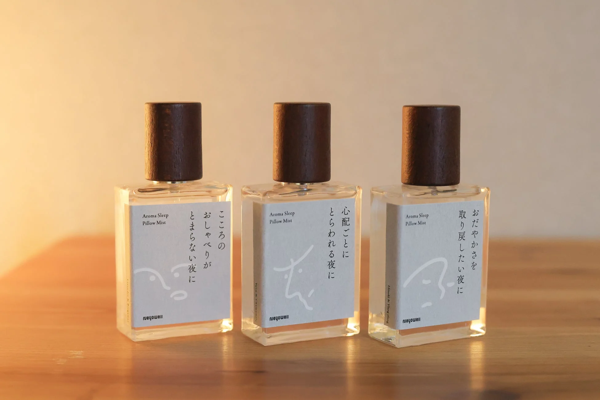 3本のアロマスリープピローミストが木製のテーブルに並べられている