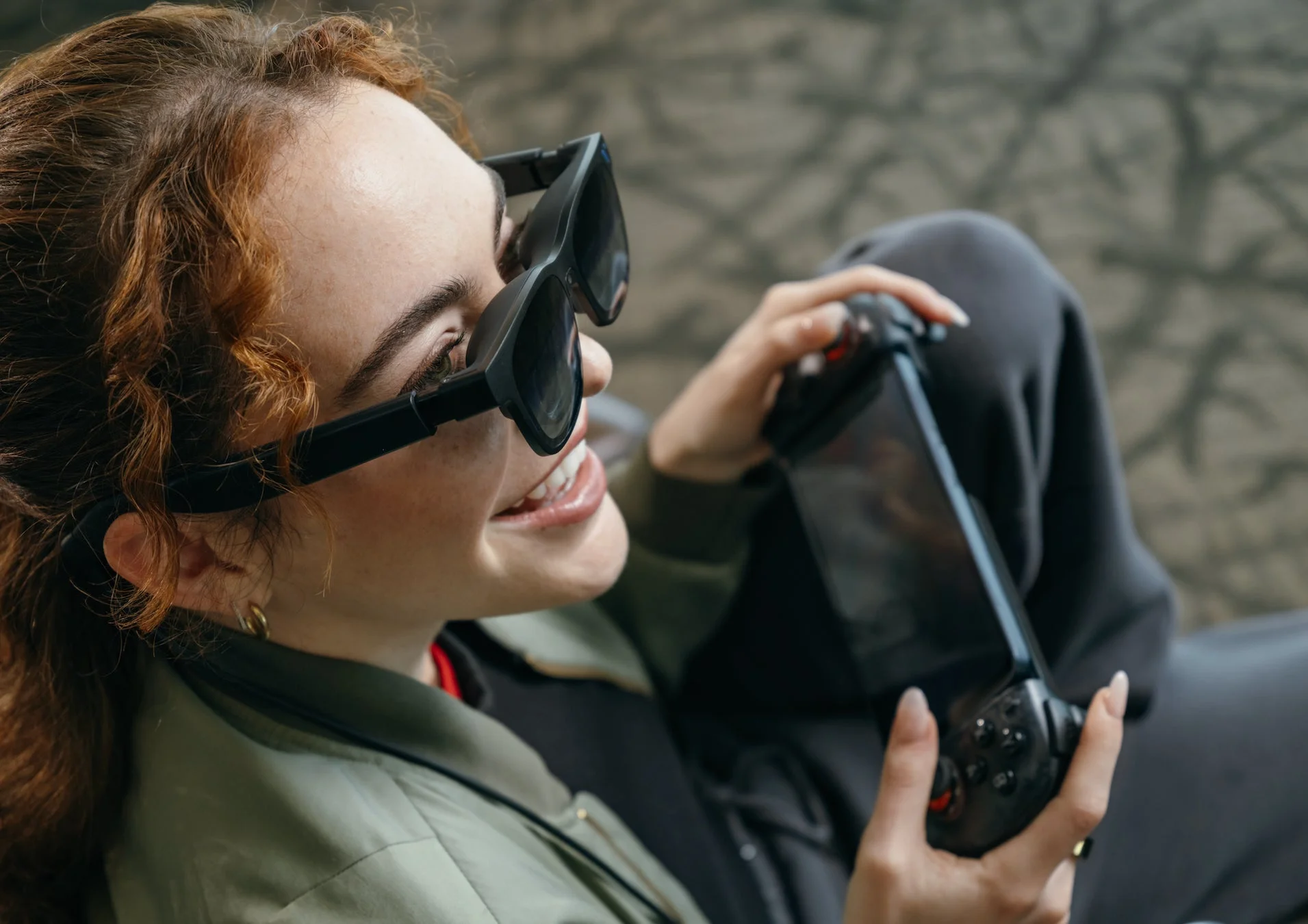 スマートグラスをかけゲーム機を操作する女性