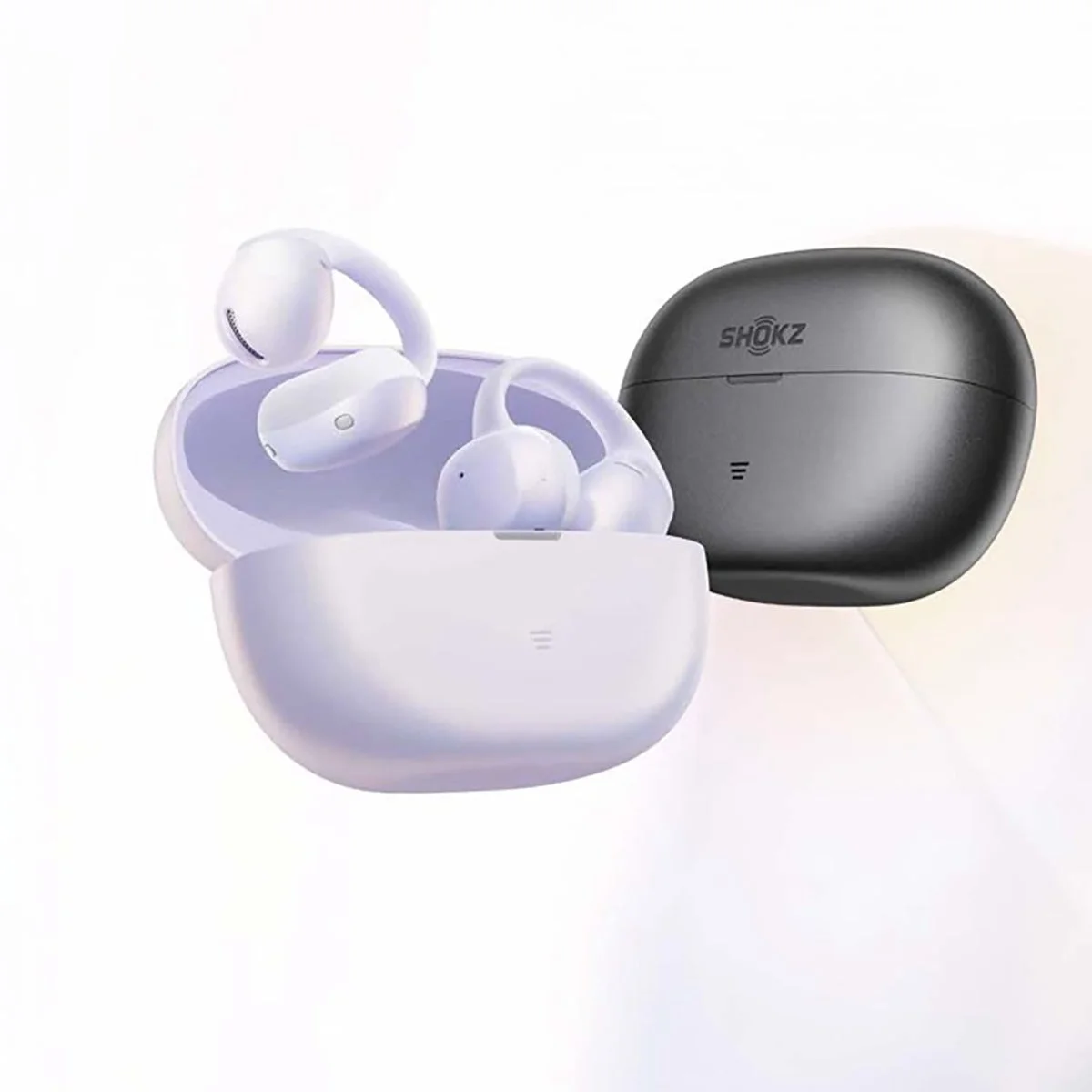 白いワイヤレスイヤホンが収納された充電ケースと、その隣に置かれた黒いSHOKZブランドの充電ケースが写っています。