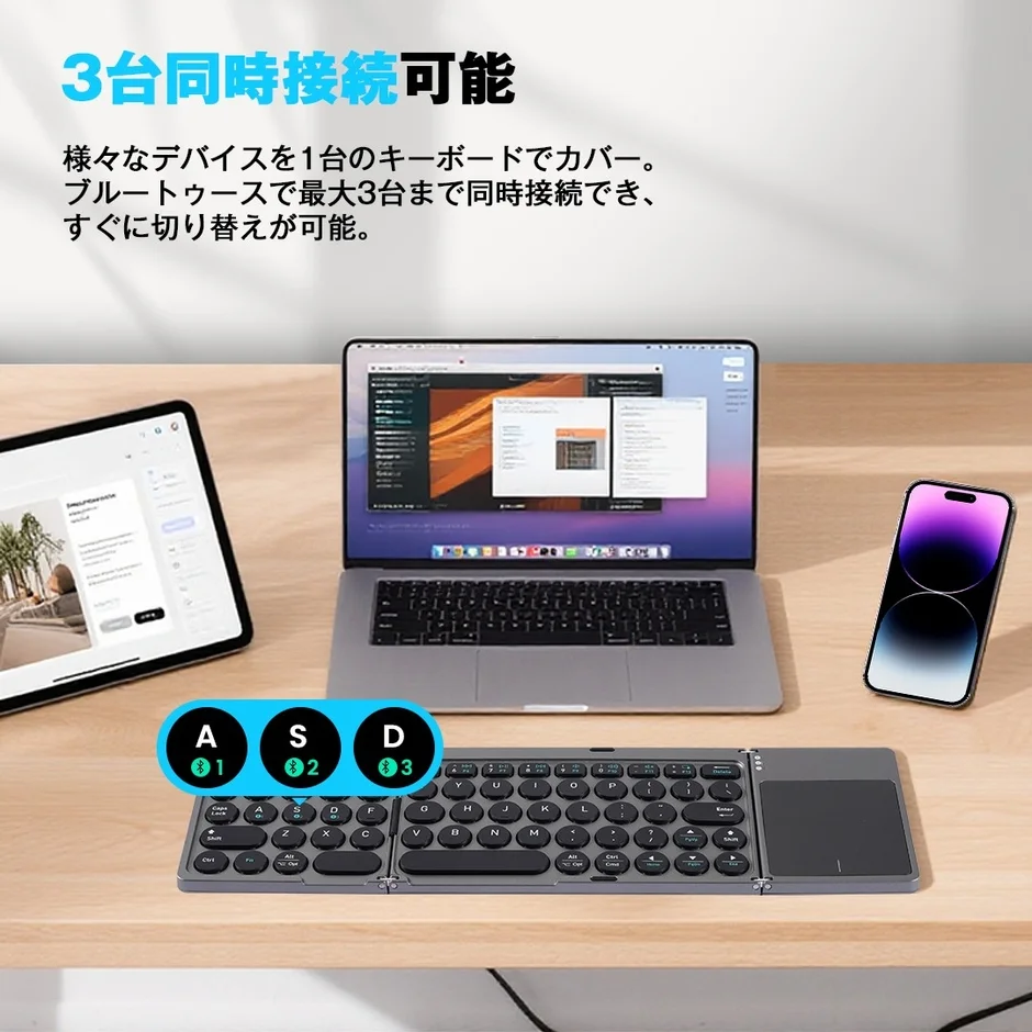 折りたたみ式のワイヤレスキーボードが、ノートパソコン、タブレット、スマートフォンの3台に同時接続されている様子。Bluetoothで最大3台まで接続し、素早く切り替えられる機能性をアピールしています。