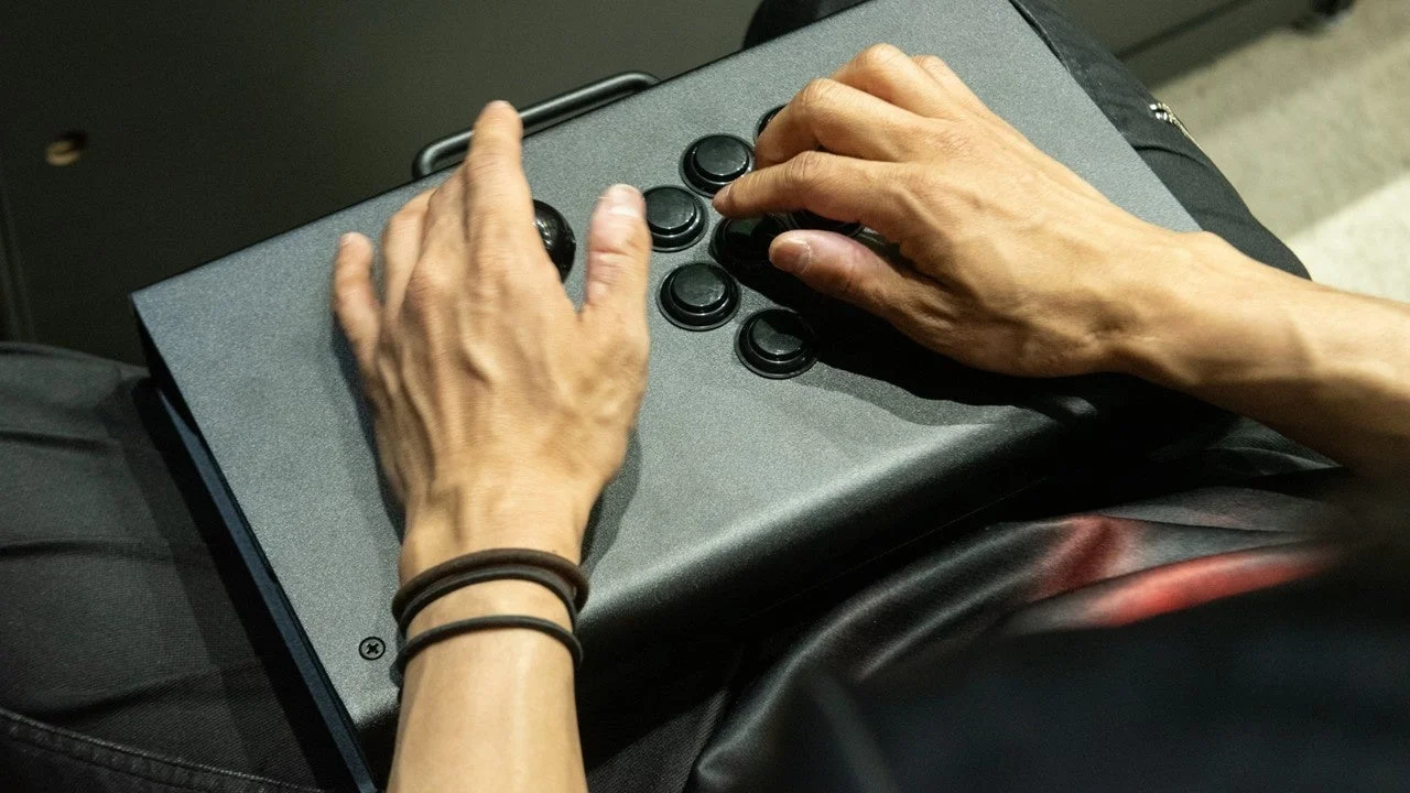 アーケードスティックを操作する手元