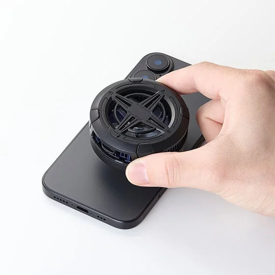 手のひらで冷却ファンをスマートフォンに取り付けようとしている様子