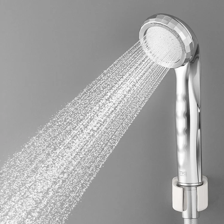 シャワーヘッドから勢いよく水が噴き出している様子