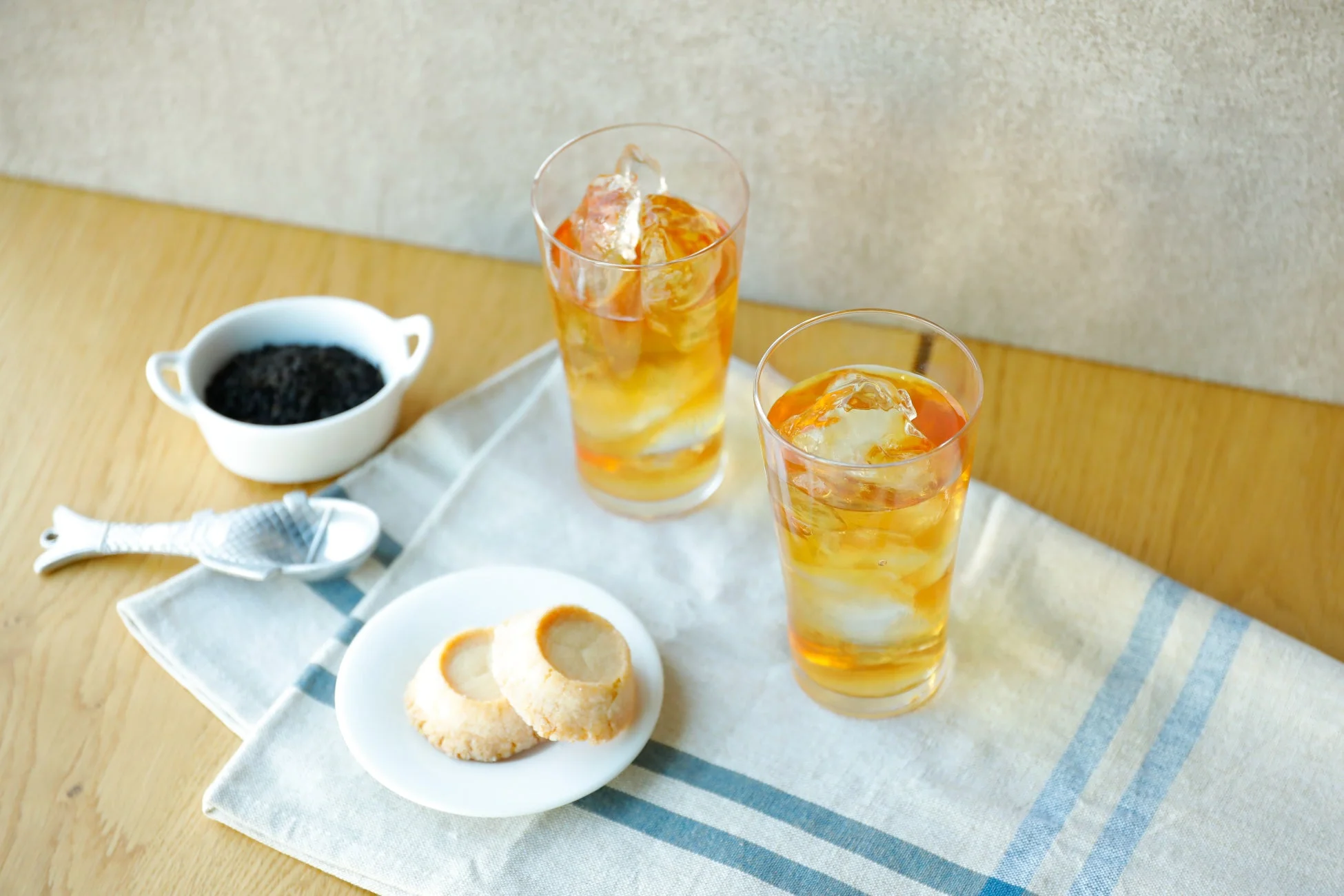 木製のテーブルに、氷入りグラスの飲み物2つとクッキー
