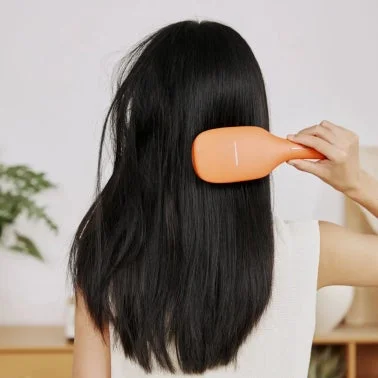 スカルプケア美髪ブラシを使用する女性