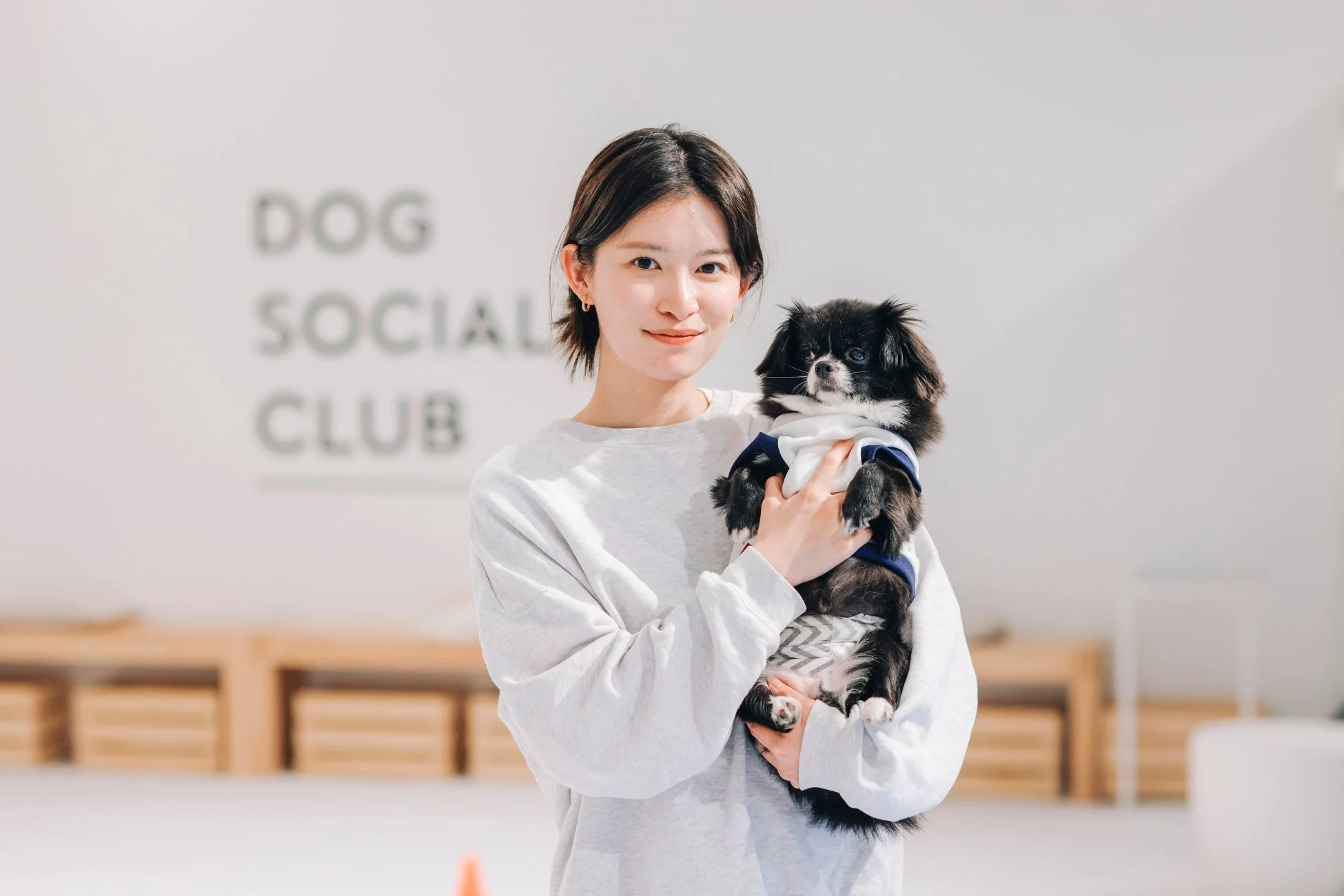 犬を抱く女性とDOG SOCIALIZE CLUB