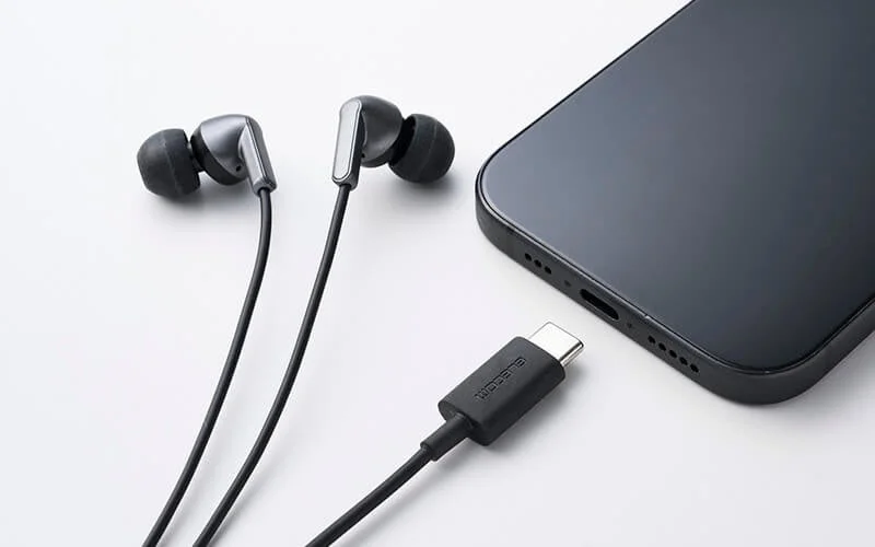 黒い有線イヤホンとUSB-Cポートを持つスマートフォン