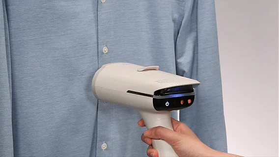 水色のシャツにしわ伸ばしをするハンディ衣類スチーマー