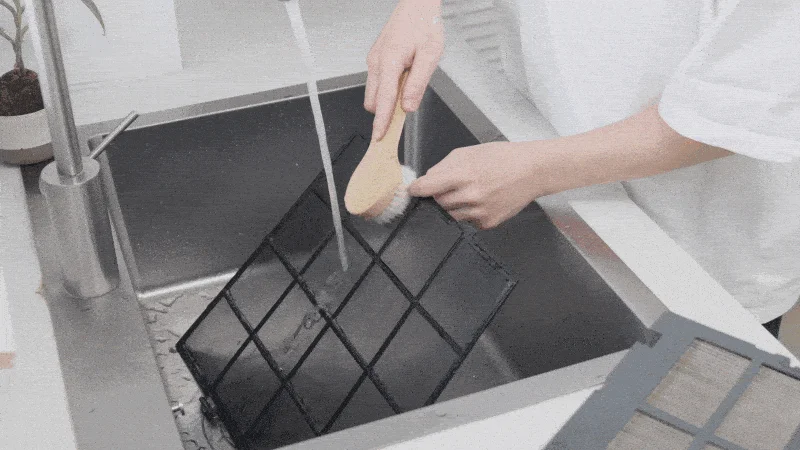 シンクでフィルターを水洗いしている様子