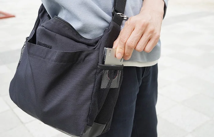ショルダーバッグから取り出す様子