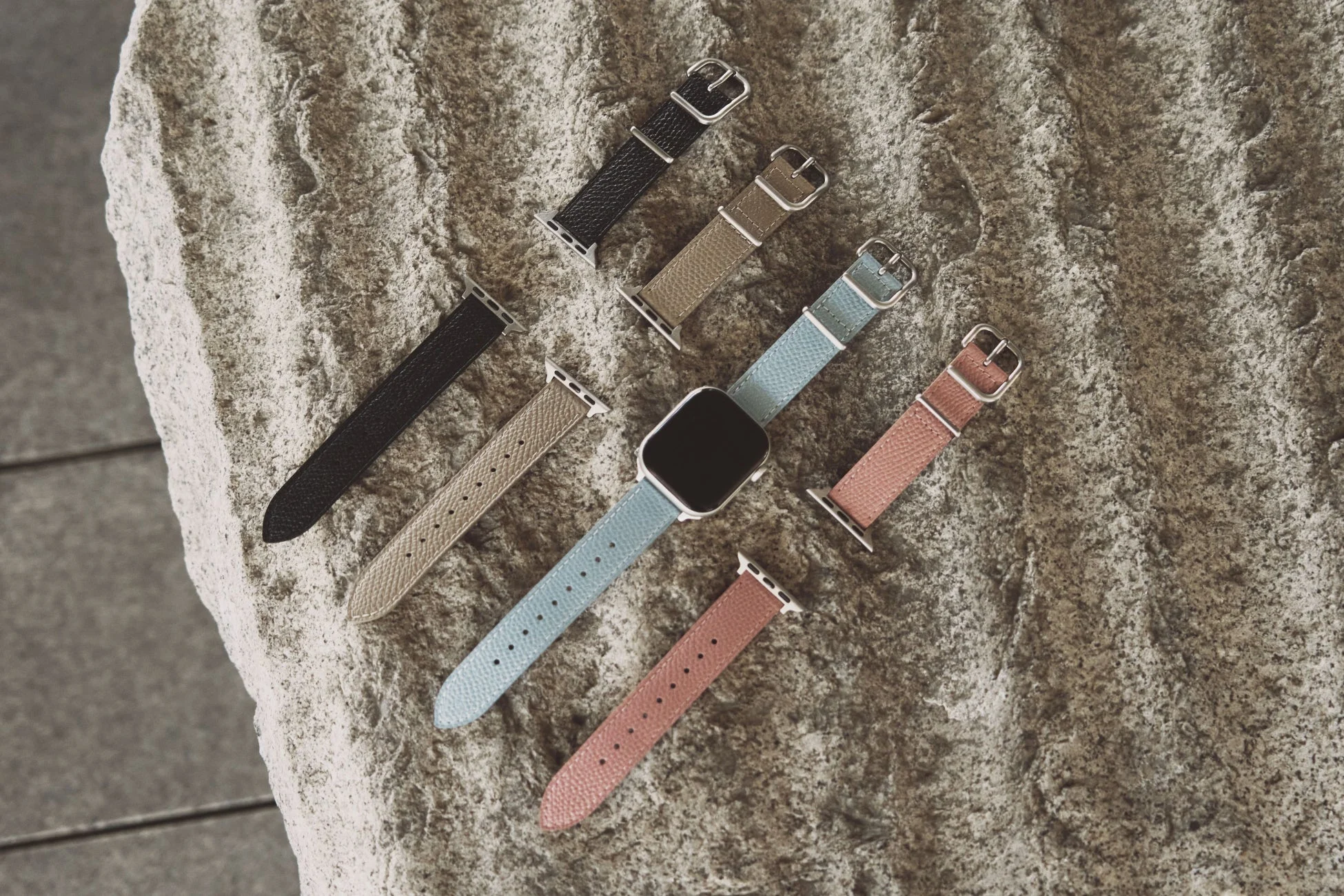 様々な色の交換用バンドが並べられたApple Watch