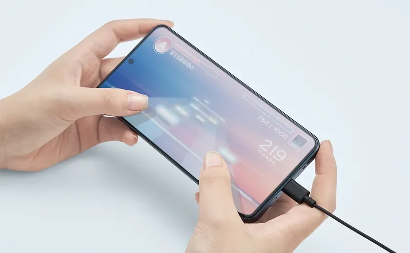 人物がスマートフォンを横向きに持ち、ゲームをプレイしている様子