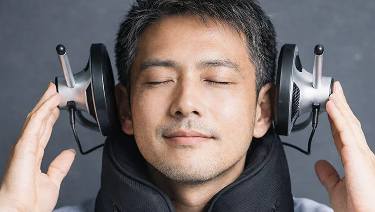 目を閉じてリラックスした男性がデバイスを装着