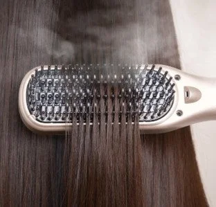 ヘアアイロンブラシで髪を整える様子