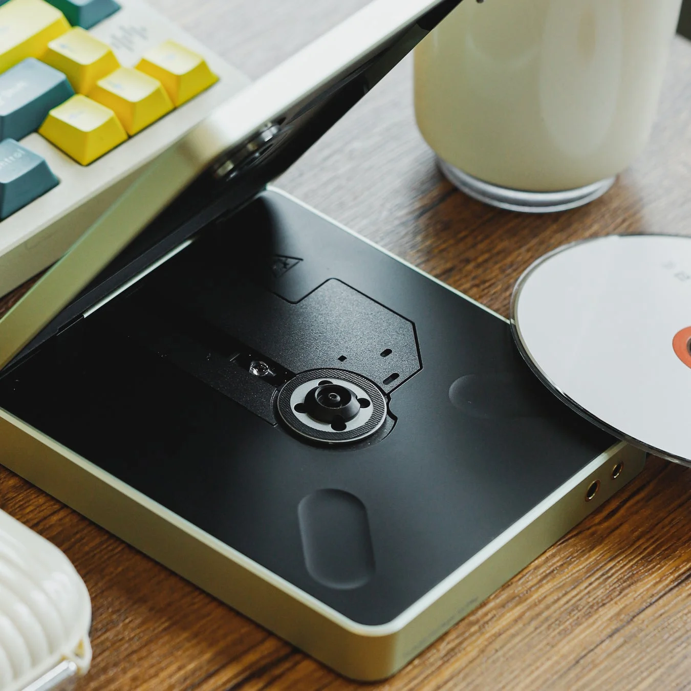 蓋を開けたポータブルCDプレーヤーとCDディスク