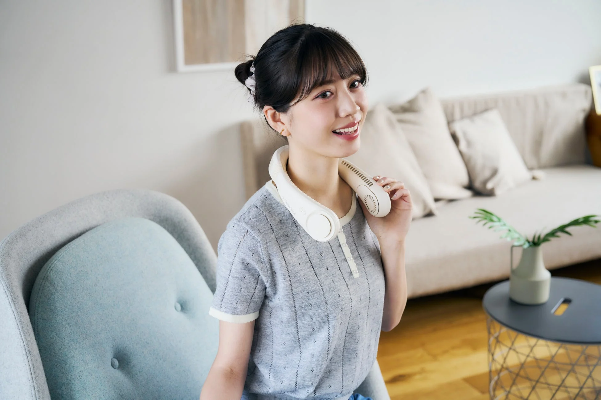 首掛け扇風機を装着し笑顔の女性