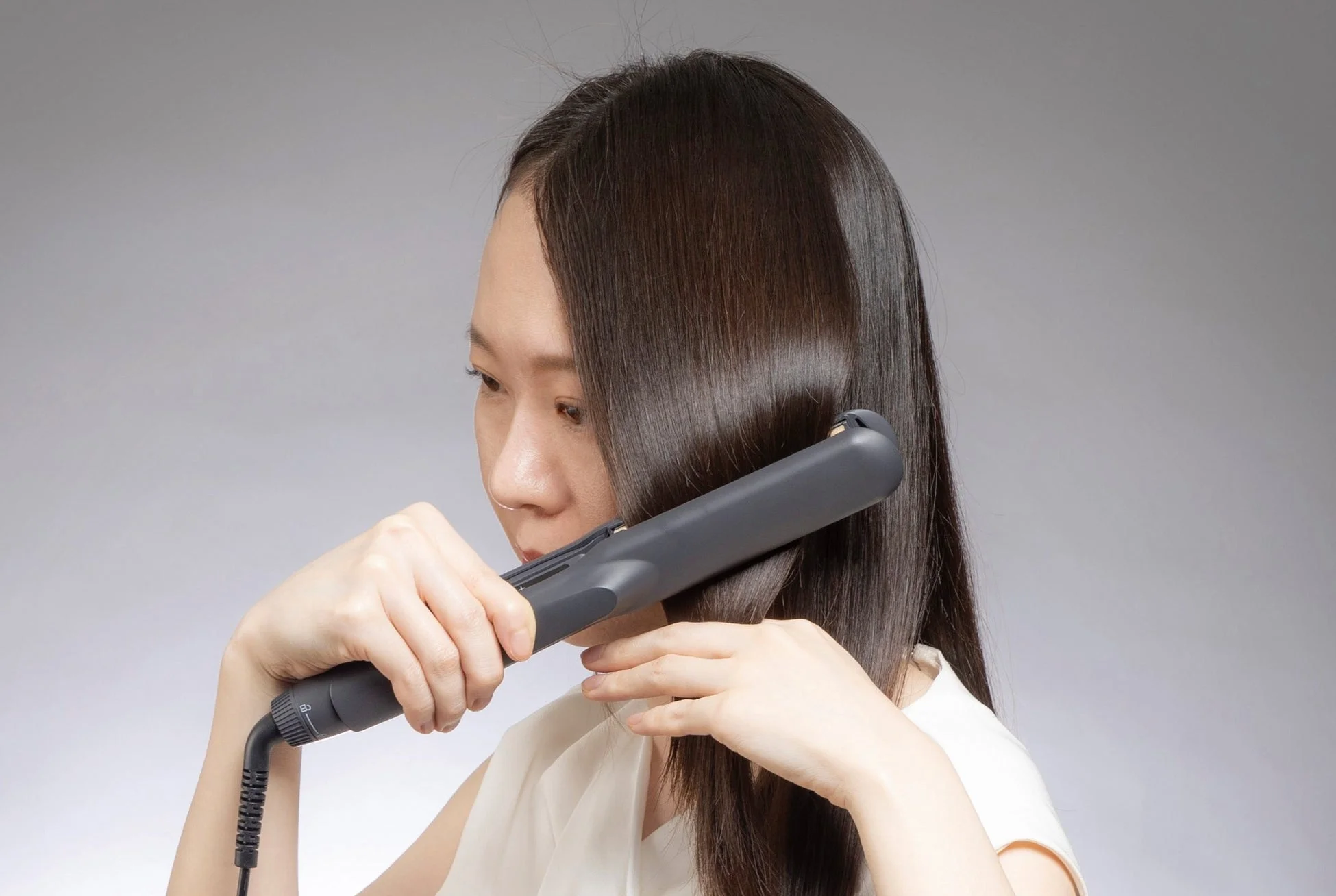 女性がヘアアイロンを使用している様子