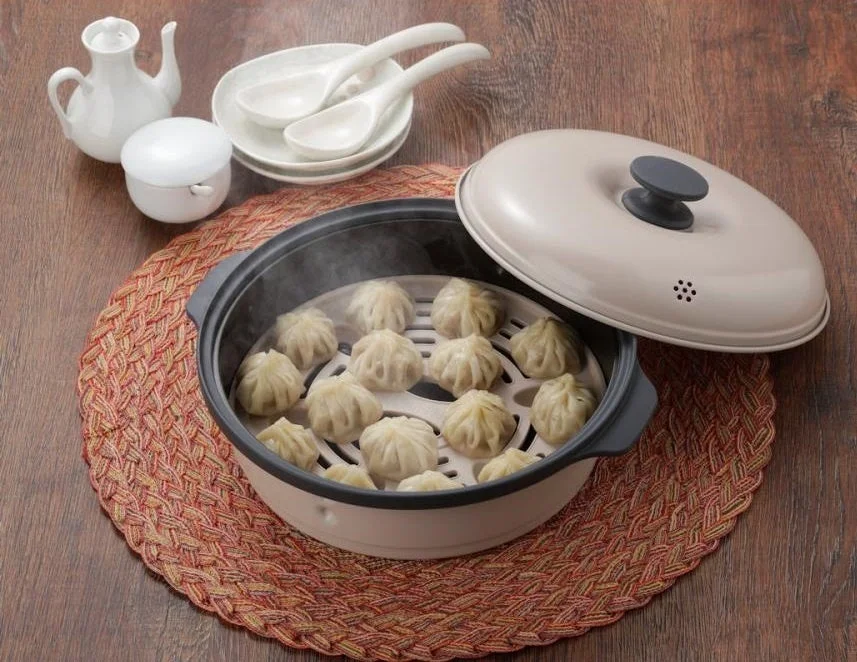 木製のテーブルの上に置かれた蒸し器で、たくさんの点心(餃子や焼売)が湯気を立てて蒸されている