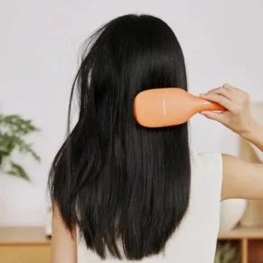 女性がヘアブラシで髪をブラッシングしている様子