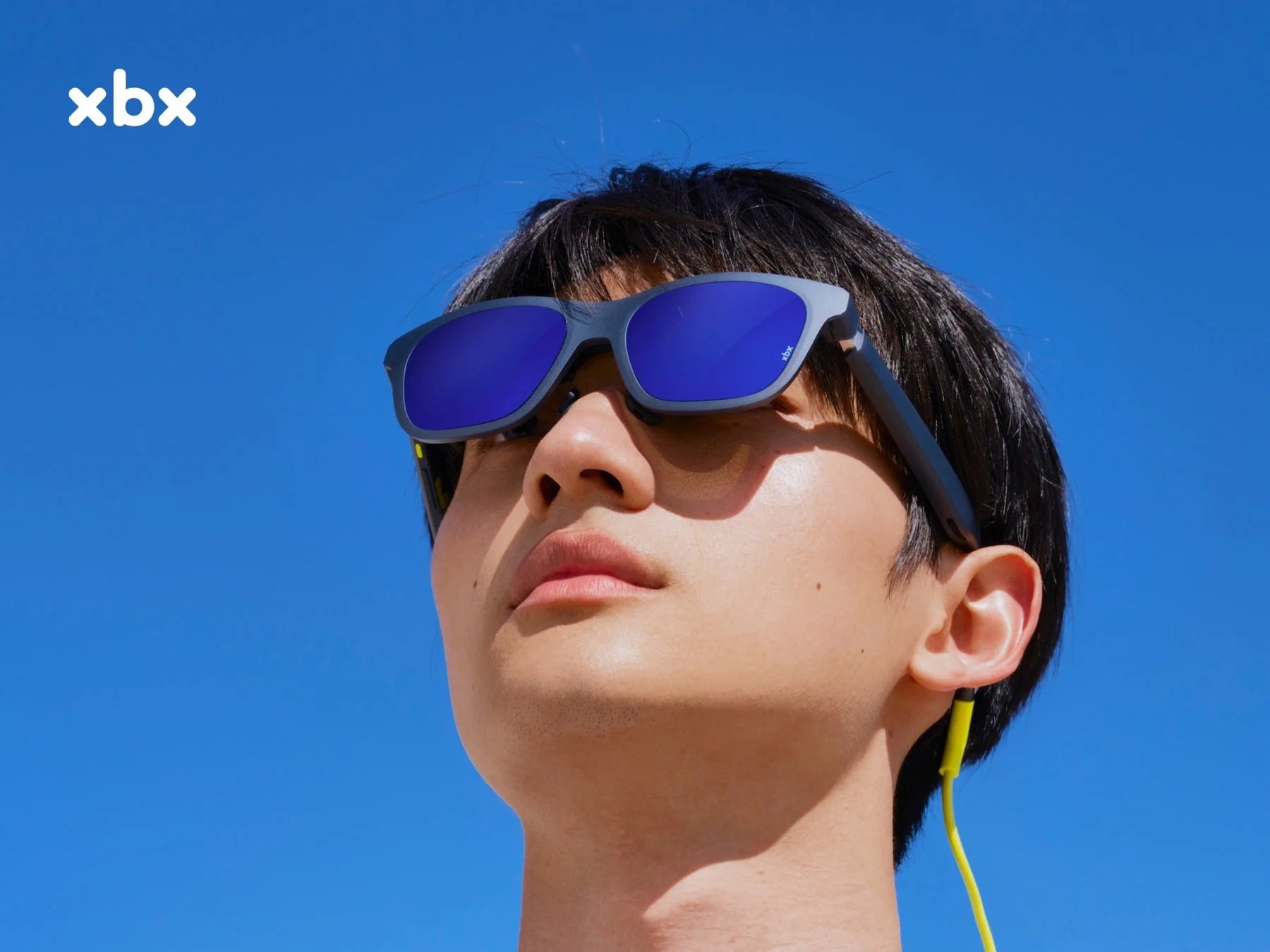 xbxスマートグラスを装着し青空を見上げる男性