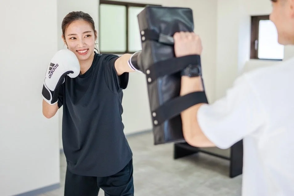 女性がボクシングのミット打ちをする様子