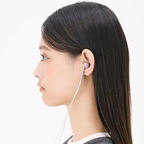 有線イヤホンを耳につけた若い女性の横顔