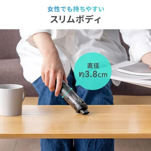 女性が木製テーブルの上でスリムなハンディクリーナーを使用している様子。直径約3.8cmのスリムボディで女性でも持ちやすいことをアピールしています。