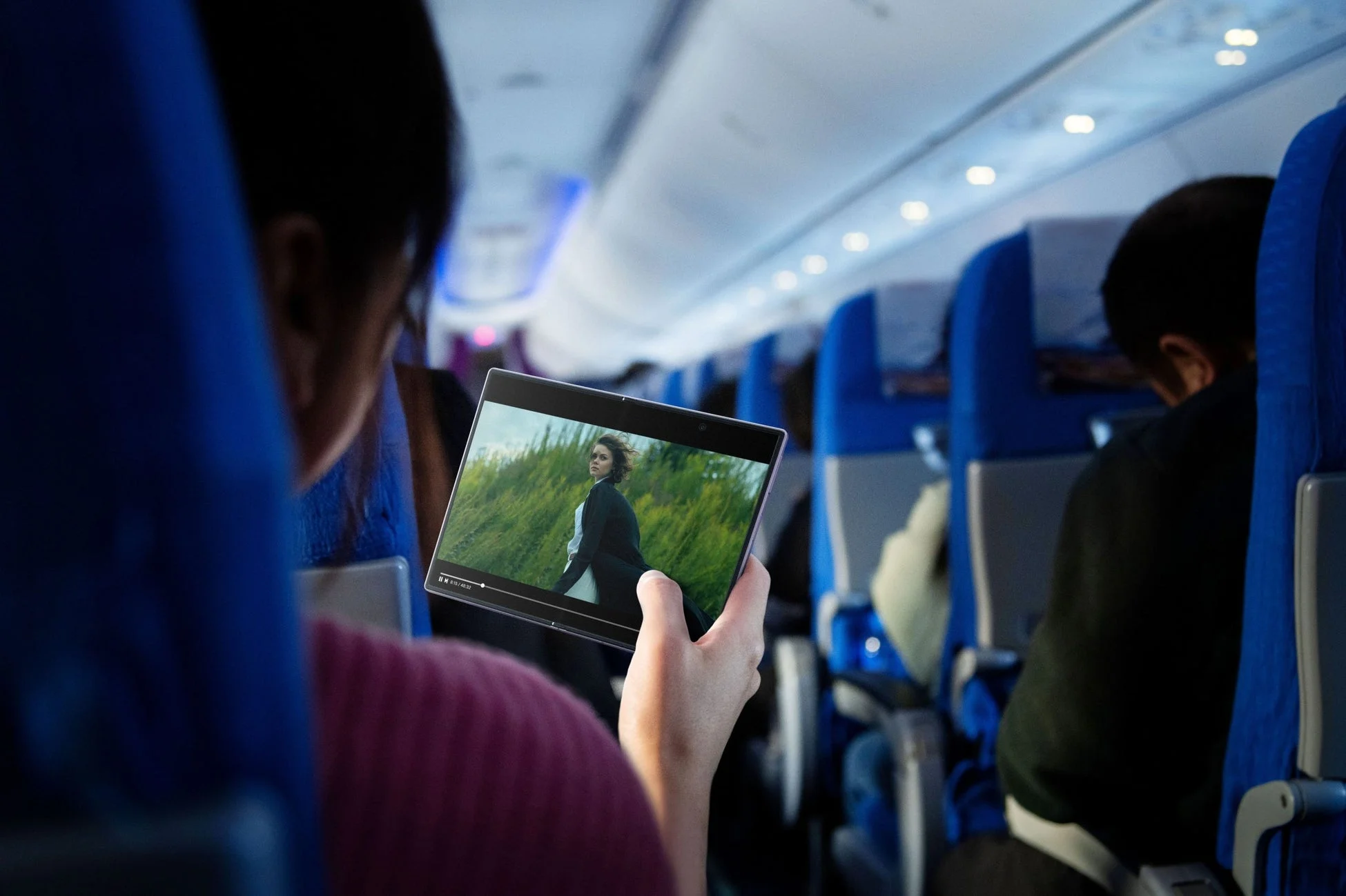 飛行機内でタブレットで動画を視聴する様子
