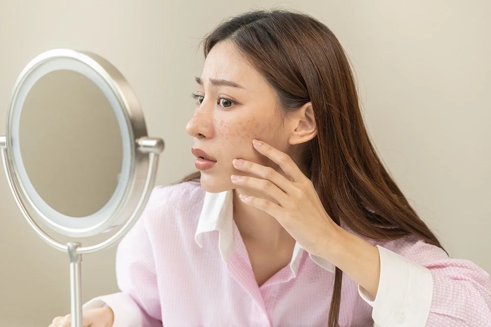 鏡で肌の状態を確認する女性