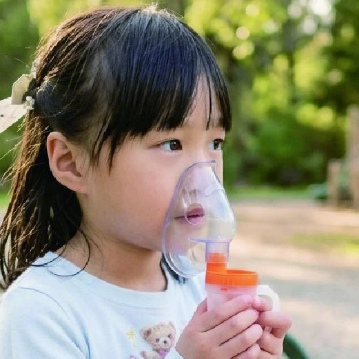 屋外で吸入器を使用する子供