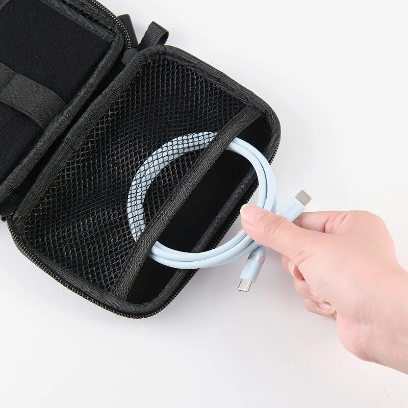 黒い収納ポーチのメッシュポケットから、水色のUSB-Cケーブルを出し入れしている様子を上から捉えた画像