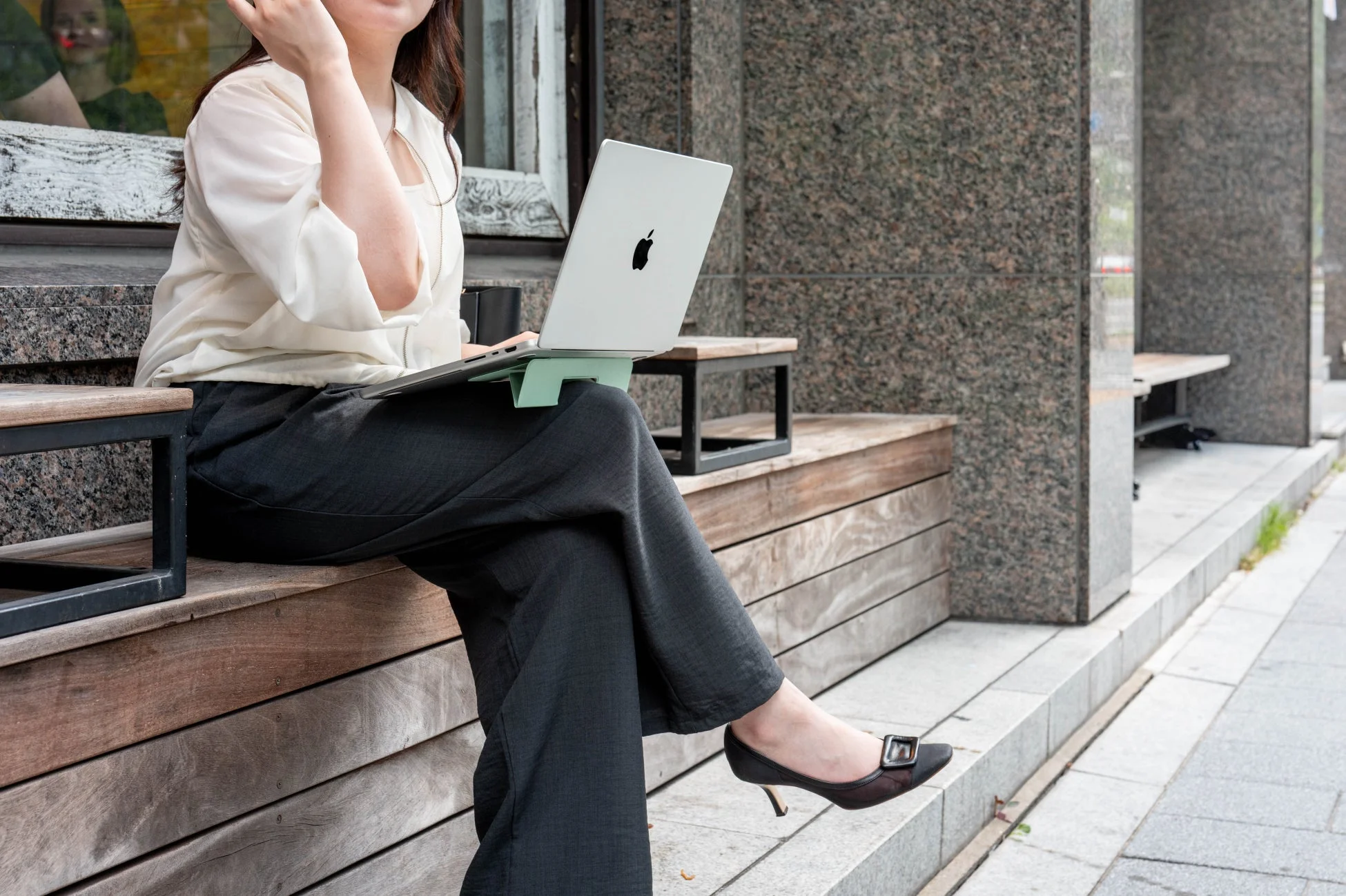 屋外でPCを使用する女性