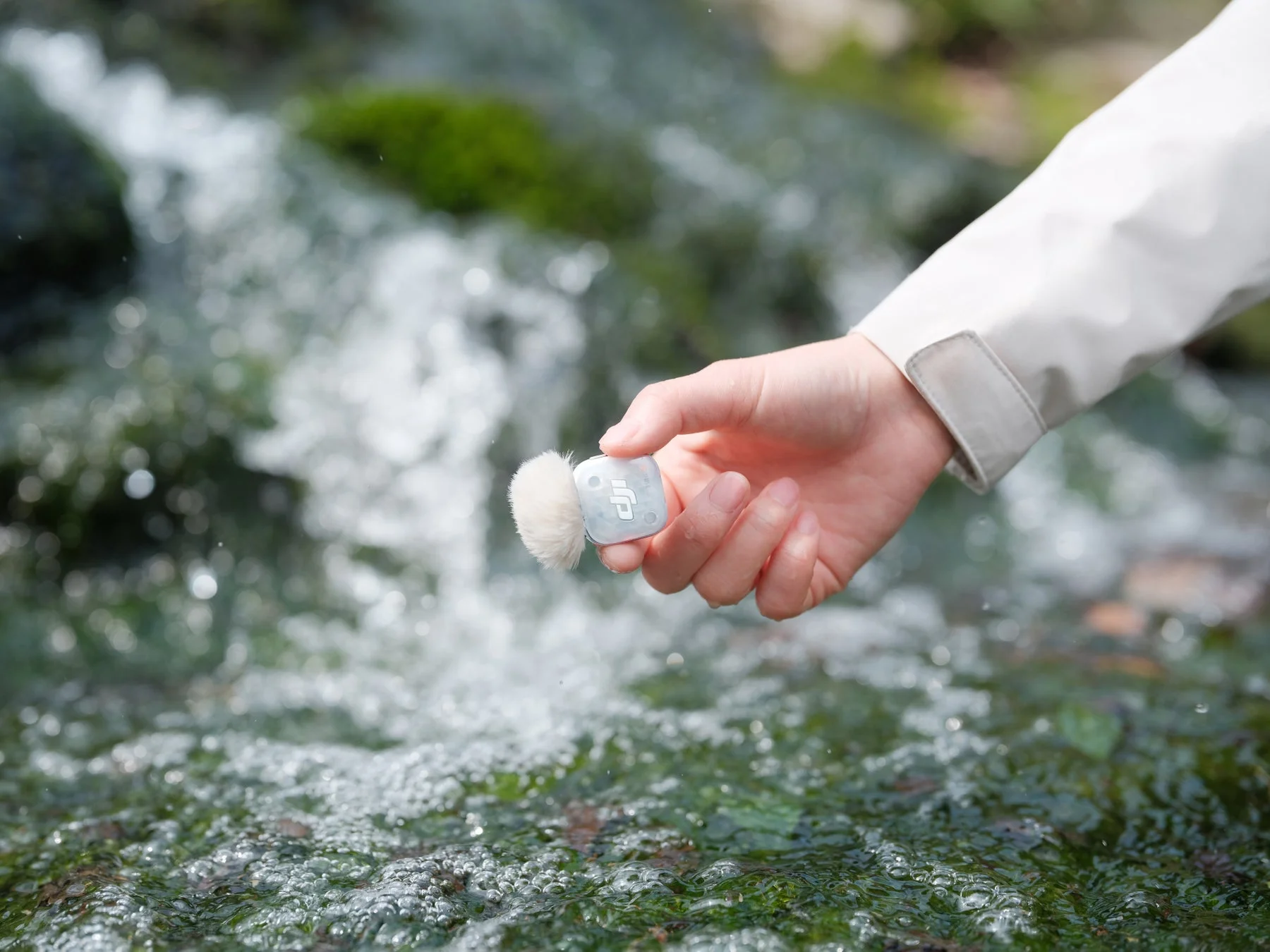 水辺でマイクを構える手